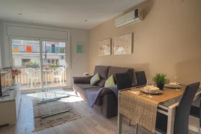 a living room with a couch and a table at Orquidea Apartment by Hello Homes Sitges in Sitges