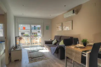 a living room with a couch and a table at Orquidea Apartment by Hello Homes Sitges in Sitges