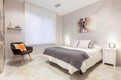a bedroom with a king sized bed and a chair at Urban Sabadell in Sabadell