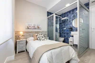 a bedroom with a large bed and a bathroom at Urban Sabadell in Sabadell