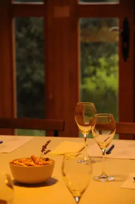 a table with two wine glasses and a bowl of food at Masia de Vallforners in Tagamanent