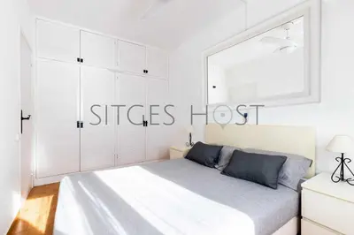 a white bedroom with a bed and a window at Sitges Casa del Mar - Impresionantes vistas al mar in Sitges