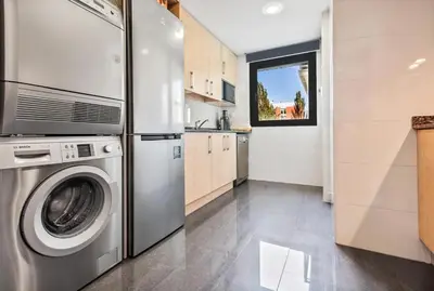 a kitchen with a refrigerator and a washing machine at Barcelona-Forum Apartments in Barcelona