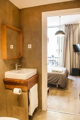 a bathroom with a sink and a bed in a room at Cien in Barcelona