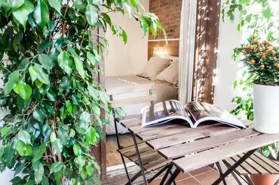a balcony with a wooden table and a book at Cien in Barcelona
