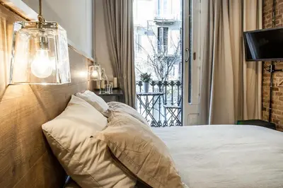a bedroom with a bed with pillows and a window at Cien in Barcelona