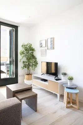 a living room with a couch and a table at Urban Suites Sitges Apartments by PriorityVillas in Sitges