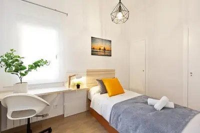 a bedroom with a bed and a desk and a chair at Confort apartamentos en playa, 3 DRM in Barcelona