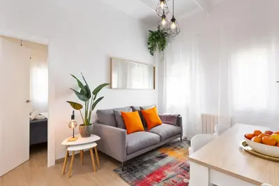 a living room with a gray couch and orange pillows at Confort apartamentos en playa, 3 DRM in Barcelona
