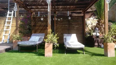 two chairs sitting on the grass in a backyard at Villa Mar & Natura Sitges in Canyelles