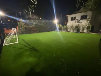 a green soccer field at night with a goal at Villa Bella Vista in Castelldefels