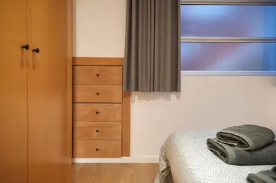a bedroom with a bed and a dresser and a window at SUN RAMBLA CATALUNYA GAUDI (Limpieza Desinfección) in Barcelona