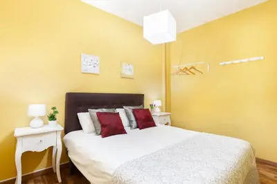a bedroom with a large white bed with red pillows at Click&Flat Fira Gran Via in Hospitalet de Llobregat