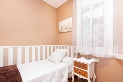 a small bedroom with a bed and a window at Click&Flat Fira Gran Via in Hospitalet de Llobregat