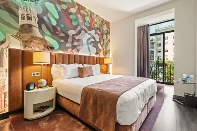 a bedroom with a king sized bed and a large window at Hotel Indigo Barcelona - Plaza Catalunya 4Sup by IHG in Barcelona