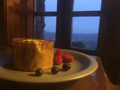 a plate with strawberries on a table with a window at CAN LLOBET Espai Rural Slow in Fogars de Montclus