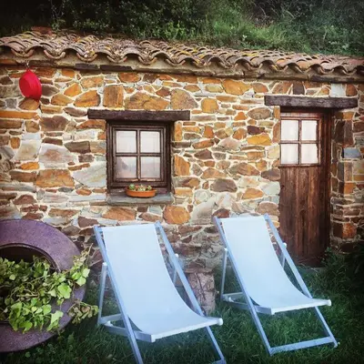 two chairs sitting in front of a stone building at CAN LLOBET Espai Rural Slow in Fogars de Montclus