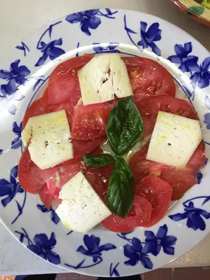 a plate of food with cheese and tomatoes and spinach at CAN LLOBET Espai Rural Slow in Fogars de Montclus