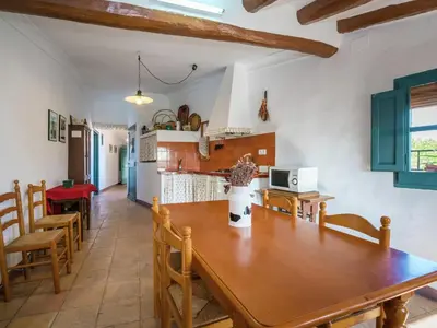 a kitchen and dining room with a wooden table and chairs at Cottage in Pacs near St Marti Sarroca Castle in Pacs del Penedes