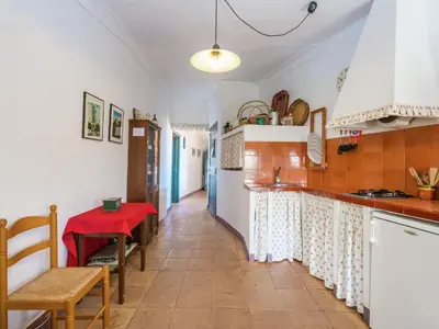 a kitchen with a counter and a red table at Cottage in Pacs near St Marti Sarroca Castle in Pacs del Penedes