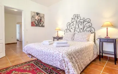 a bedroom with a bed with a large headboard at Spacious House in Can Trabal in Can Trabal