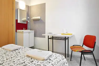 a room with a bed and a table and a chair at Hostal River in Barcelona