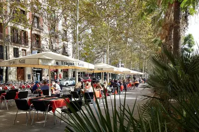 a group of people sitting at tables and umbrellas at Hostal River in Barcelona