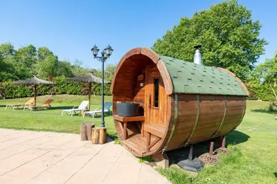 a small wooden hobbit house in a park at Agroturisme Can Burguès in Santa Eulalia de Ronsaná
