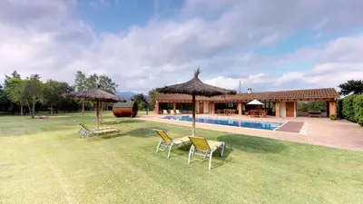 a yard with chairs and umbrellas and a swimming pool at Agroturisme Can Burguès in Santa Eulalia de Ronsaná