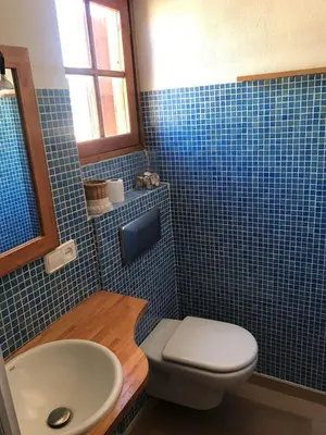a blue tiled bathroom with a toilet and a sink at Espectacular apartamento cerca de Barcelona con free wifi in Canet de Mar