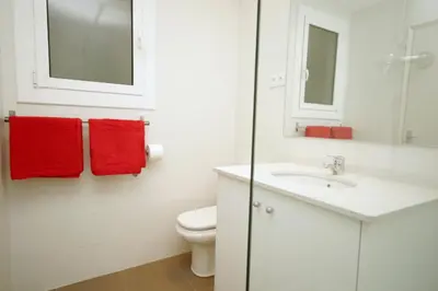 a bathroom with a toilet and a sink and red towels at Sant Antoni Market in Barcelona