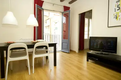 a living room with a table and chairs and a television at Sant Antoni Market in Barcelona