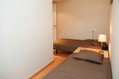 a small bedroom with two beds and a lamp at Sant Antoni Market in Barcelona