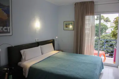 a bedroom with a bed and a large window at Hotel Alexandra Sitges in Sitges
