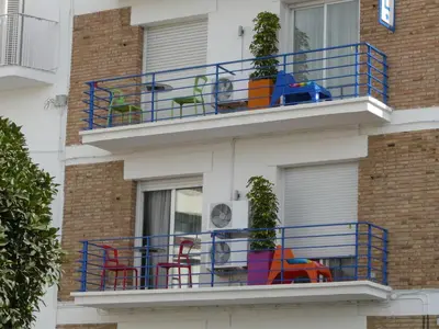 a balcony with colorful chairs on a building at Hotel Alexandra Sitges in Sitges