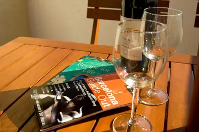 a table with a book and a glass of wine at Sant Pau Terraces Apartments in Barcelona