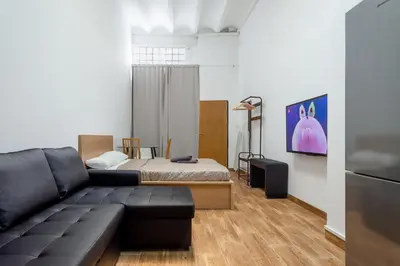a living room with a couch and a bed at CAMP NOU & FiRA BUSINESS LOFTS in Barcelona