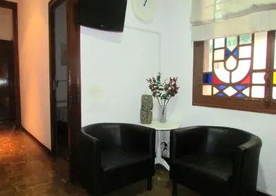 a room with two black chairs and a table with flowers at Hostal Lima in Barcelona