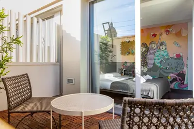 a room with a bed and a table and chairs at St Christopher's Inn Barcelona in Barcelona