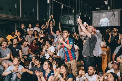 a group of people in a crowd watching a presentation at St Christopher's Inn Barcelona in Barcelona