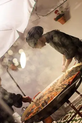 a man cooking food on top of a grill at St Christopher's Inn Barcelona in Barcelona