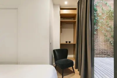 a bedroom with a bed and a chair and a window at Arte Suites by Olala! - Smart Stay in Hospitalet de Llobregat