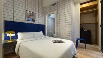 a bedroom with a white bed with a book on it at Arte Suites by Olala! - Smart Stay in Hospitalet de Llobregat