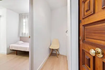 a door to a room with a bed and a chair at Quiet, Ultra-Central Stay KM0 for 3 in Barcelona