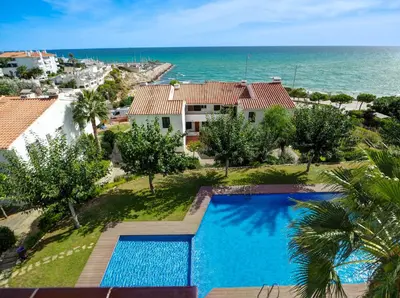 an aerial view of a villa with a swimming pool and the ocean at Amazing Seaview Apartment by Hello Homes Sitges in Sitges