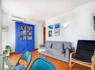 a living room with a couch and chairs and a blue door at Amazing Seaview Apartment by Hello Homes Sitges in Sitges