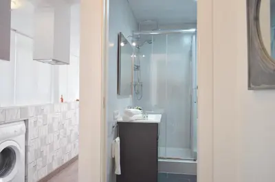 a bathroom with a shower and a sink and a washing machine at CIUDADELA PARK 1 in Barcelona