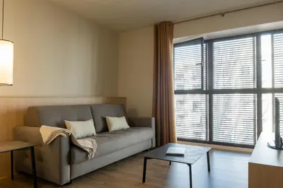 a living room with a couch and a large window at MH Apartments Urban in Barcelona