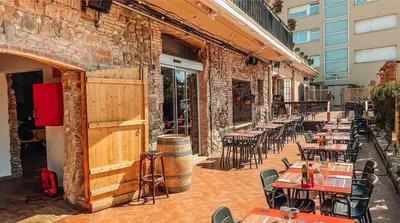 an outdoor patio with tables and chairs and a building at Hotel Consentido in Granollers