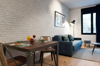 a living room with a table and a blue couch at MH Apartments Sant Pau in Barcelona